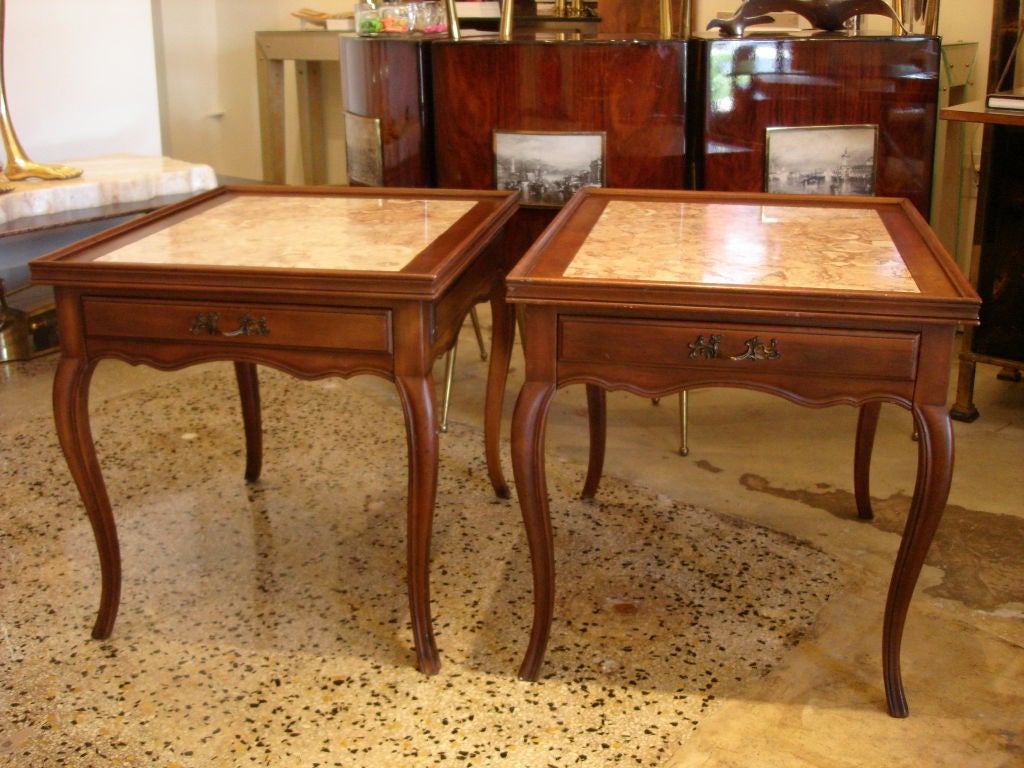 Louis XV style side/end tables by WM. A. Berkey Co. a division of John Widdicomb. Cabriolet legs, one drawer (label inside), carved design around edge and topped with soft pink Italian marble make this pair truly beautiful.  <br />
Note: They are