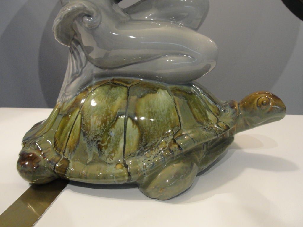 Featuring original fiberglass oversized shades and ceramic fish finials, this matching pair of Deco lady holding a fabulously articulated fish atop a turtle are extremely rare.  These lamps are much larger than appear in the main picture.<br />
<br