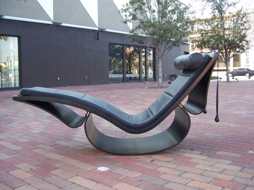 A sculptural rocking chaise longue in black painted laminated wood frame with leather upholstery and adjustable, counterbalanced headrest. Designed by Oscar Niemeyer manufactured by Fasem, Italian, circa 1970. 

Mr. Niemeyer recently passed away