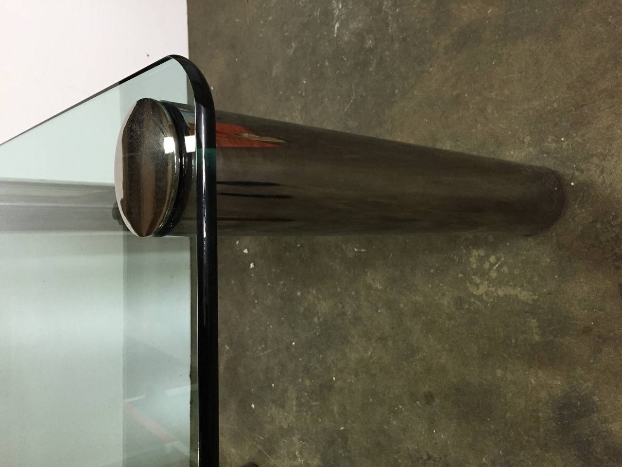 Rounded edge thick glass and chromium finish cylinder legs.