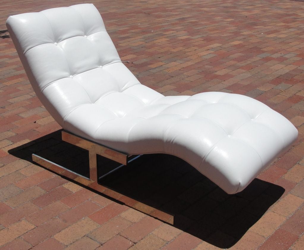 THIS HAS BEEN REDUCED FROM $3,800. THIS IS THE FINAL NET PRICE, NO ADDITIONAL DISCOUNTS.  A wave form chaise in tufted White leatherette upholstery with Chrome base. By Milo Baughman.