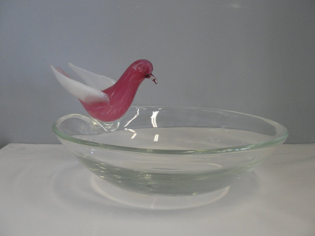 Pink opalescent murano bird sitting on a clear large bowl.

This item is currently in our MIAMI facility. Please call or email us directly for details.