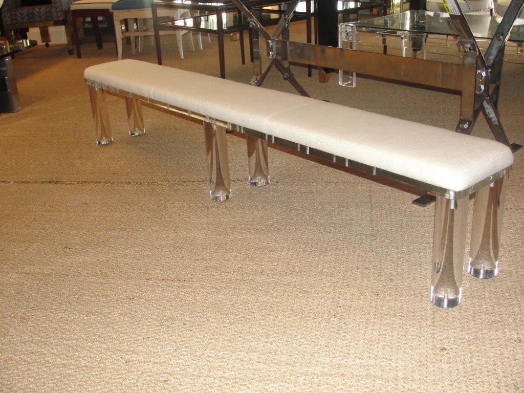 In the style of Karl Springer, this extra long lucite bench upholstered in cotton/linen fabric. Cylinder legs on lucite platform and simply stunning! Perfect for foyer, window-side or end of king size bed frame.