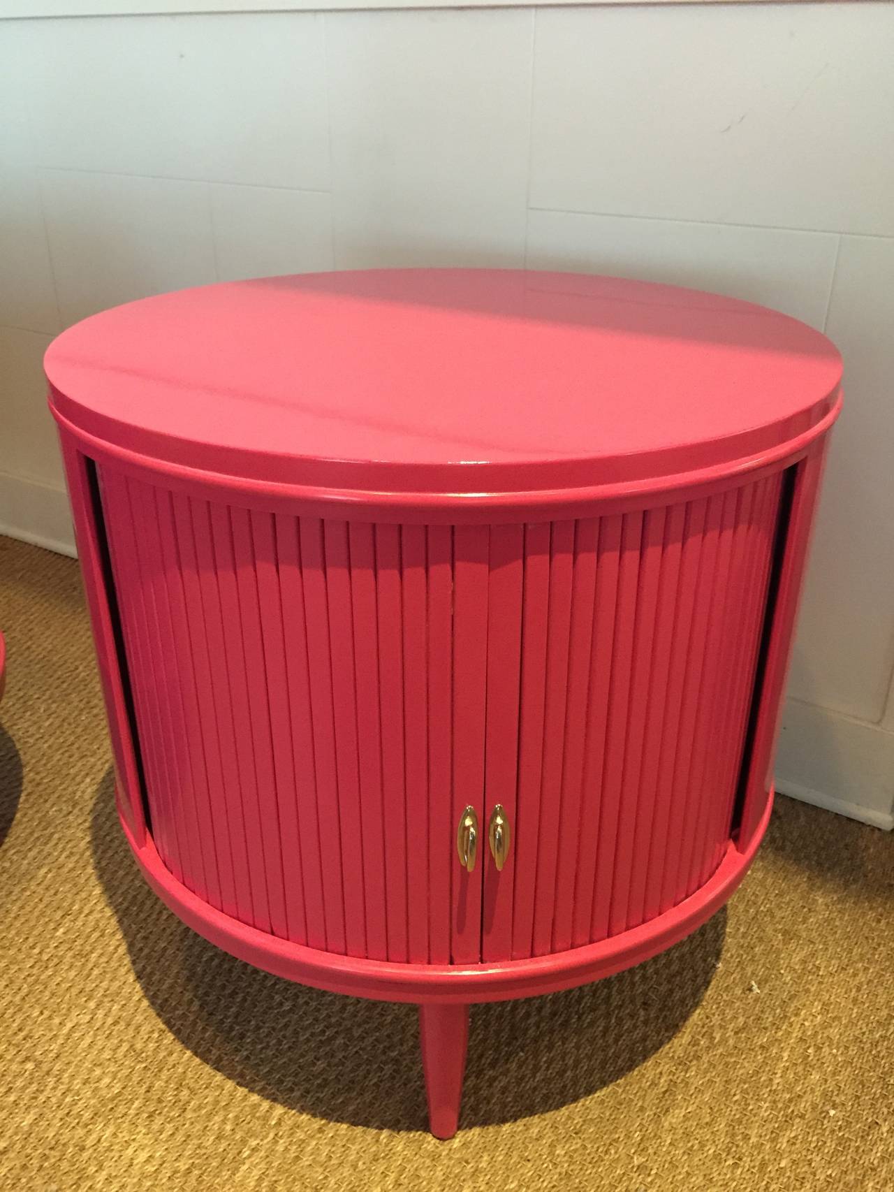 A whimsical touch of vibrant color with rolling slider doors and two interior drawers on sculptural leg base. Perfect for a bedroom or living room/den.