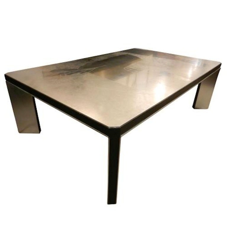 A large scaled modernist cocktail table featuring a body and top in acid etched steel done in a abstract pattern. The table also features ebonized details and diagonally placed corner legs. In the style of Christian Krekels, Belgium circa 1970.