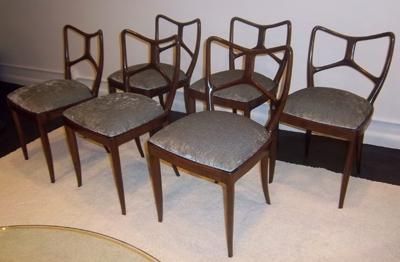 A Set of six dining chairs each featuring frames in solid Mahogany with low shaped back rests, slightly curving tapered front and splayed back legs. The chairs also feature all new upholstered seats. Fully Documented. By Enrico Ciuti, Italy circa