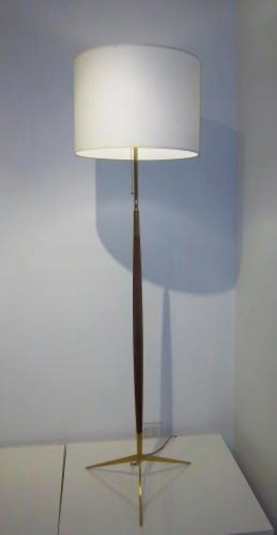 A mid century floor lamp featuring a body in shaped stained Mahogany with a tripod base as well as accents on the lamps body all in gilt brass. In the style of Ico Parisi, Italy circa 1955.