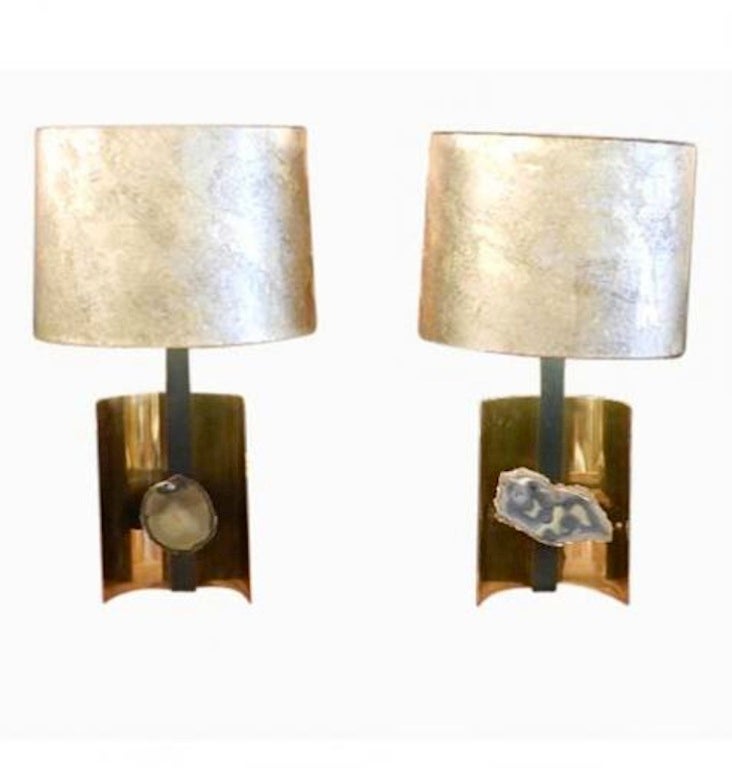 A pair of modernist table lamps each featuring bodies in demilune shaped brass with a blackened steel neck and a central decoration of a piece of naturally shaped Agate. The lamps also feature their original marbleized demilune shaped shades.