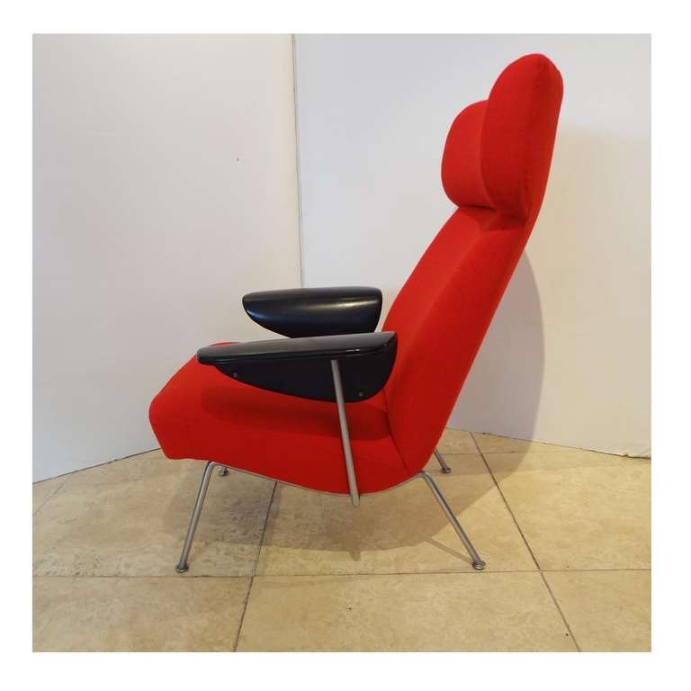 A very rare high backed single lounge chair, featuring a silver metal frame, floating curved black vinyl armrests and a slight winged headrest on the divided backrest. Flexible back. Newly upholstered in a bright red textured fabric. Theo Ruth,