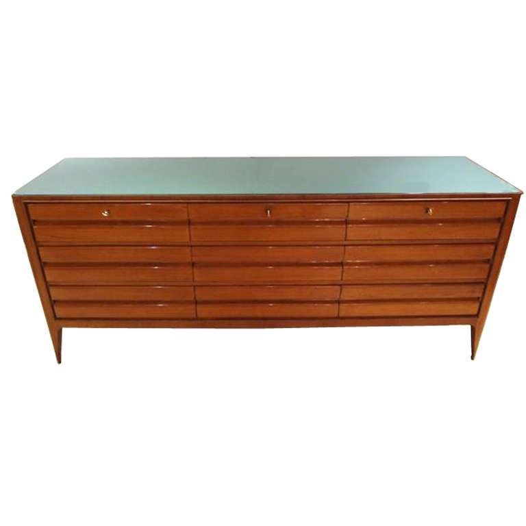 A sideboard or chest of drawers in mahogany with nine drawers and a green reverse-painted glass top. Luciano Baldessari, Italy, circa 1953.
