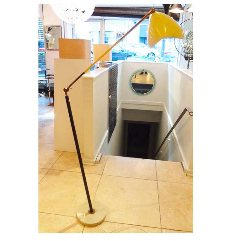 Mid-Century, sculptural floor lamp featuring a round white marble base, a diagonally mounted black steel pole body and an adjustable yellow lacquered metal top pole. Attributed to Arredoluce, Italy, circa 1952.