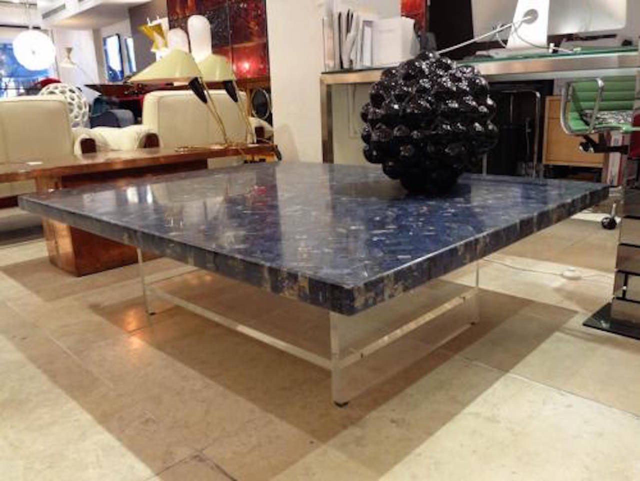 A large scaled cocktail table featuring a rectangular top in deep blue Egyptian marble which has been inlayed in a herringbone pattern using small rectangular pieces of marble the top sits on a thick lucite base with bottom shelf. Fully documented.