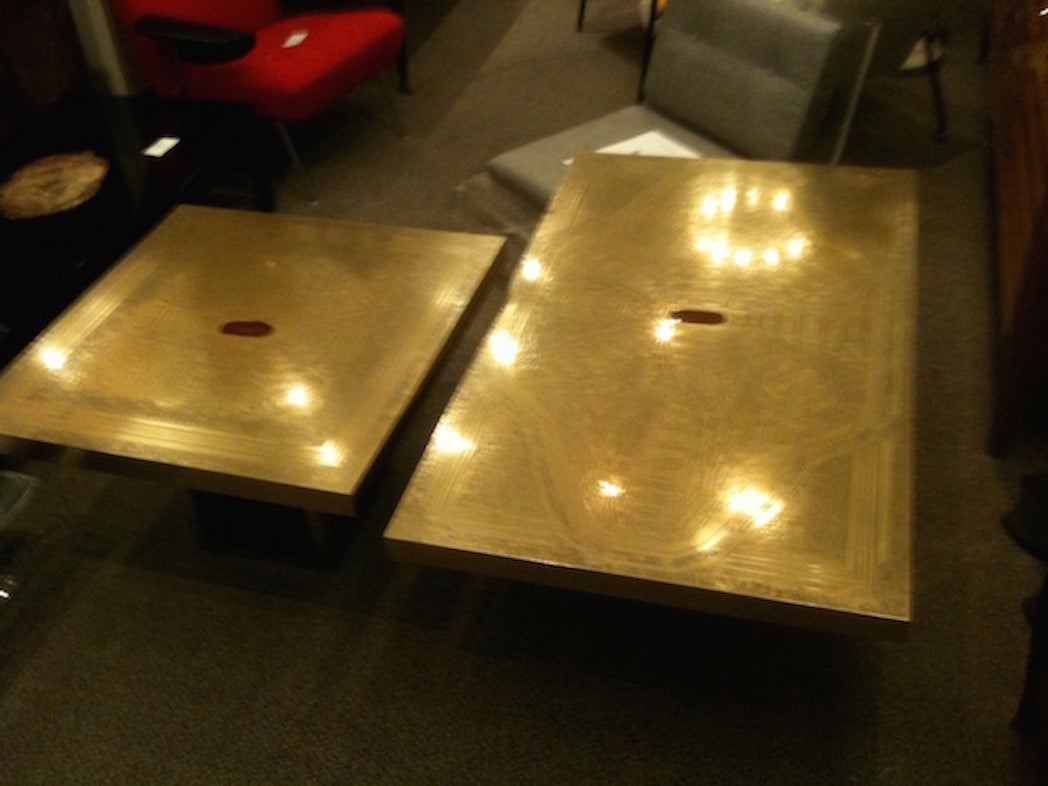 Two-piece grand scaled cocktail table featuring tops of acid etched brass with central inlays of agate done in a modernist abstract pattern. The tops are supported by simple bases in blackened wood with brass banding along their edges. There is a