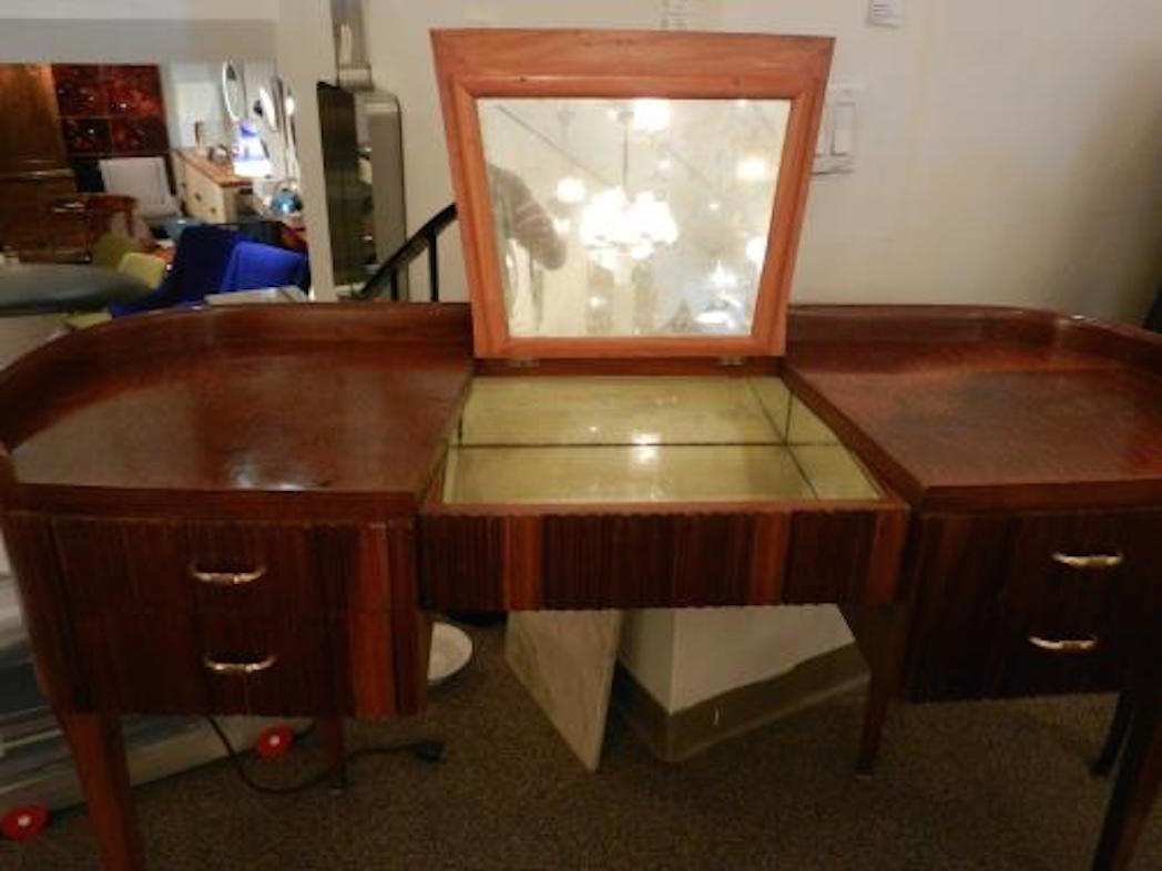 A modernist vanity or dressing table in figured burl briarwood featuring rounded sides, four drawers with reeded fronts and a central storage compartment with a lift cover and interior mirrors. Paolo Buffa, Italy, circa 1940s.