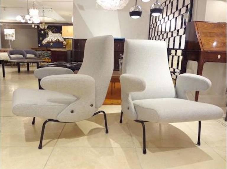 A pair of Mid-Century club chairs each featuring a shaped back and seat with applied cantilevered armrests which sit on curved, blackened metal legs. The clubs also feature all new pale grey wool upholstery. By Erberto Carboni, Italy circa 1954.