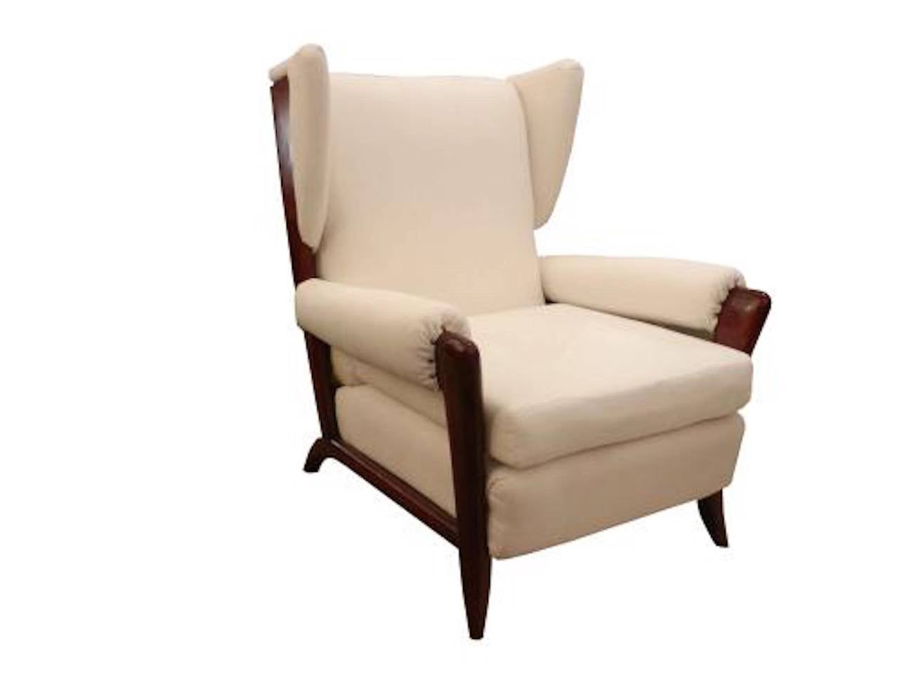 A pair of club chairs each featuring frames in stained Mahogany with small side wings, loose seat cushions, separate armrests and extended back legs. The clubs are upholstered in muslin and are ready for final upholstery. Fully documented. Paolo