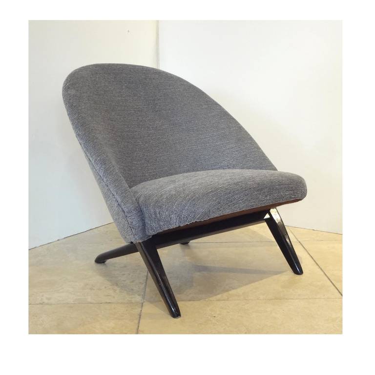 A pair of Mid-Century Modern slipper chairs each featuring a one piece rounded tight backrest and tight upholstered seat with splayed front and back legs finished in black lacquer. The chairs also feature all new upholstery, their original Artifort