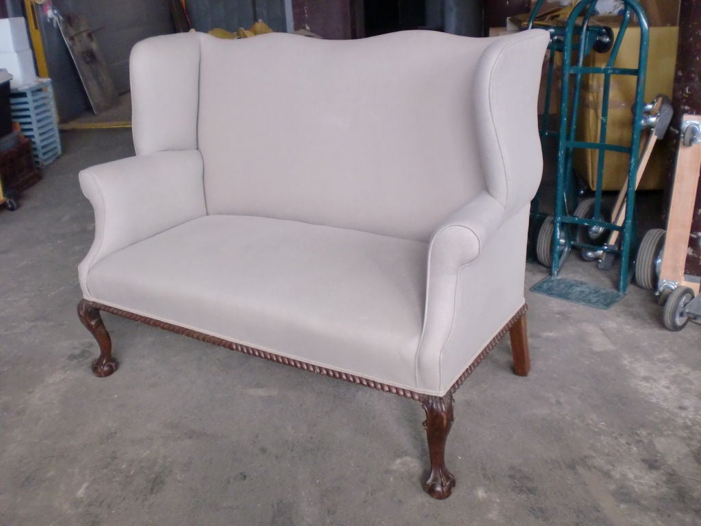 Camelback Wing Chair Arm sofa /settee with ball and claw foot.Braided wood edge.Newly reupholstered. Located in dealers warehouse