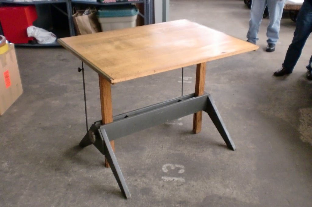 Wooden Drafting Table. Top raises and lowers and pivots from horizontal to vertical.Metal edged top.Manufactures label.Located in dealers warehouse