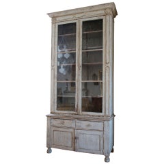 Tall painted cabinet with glazed doors.