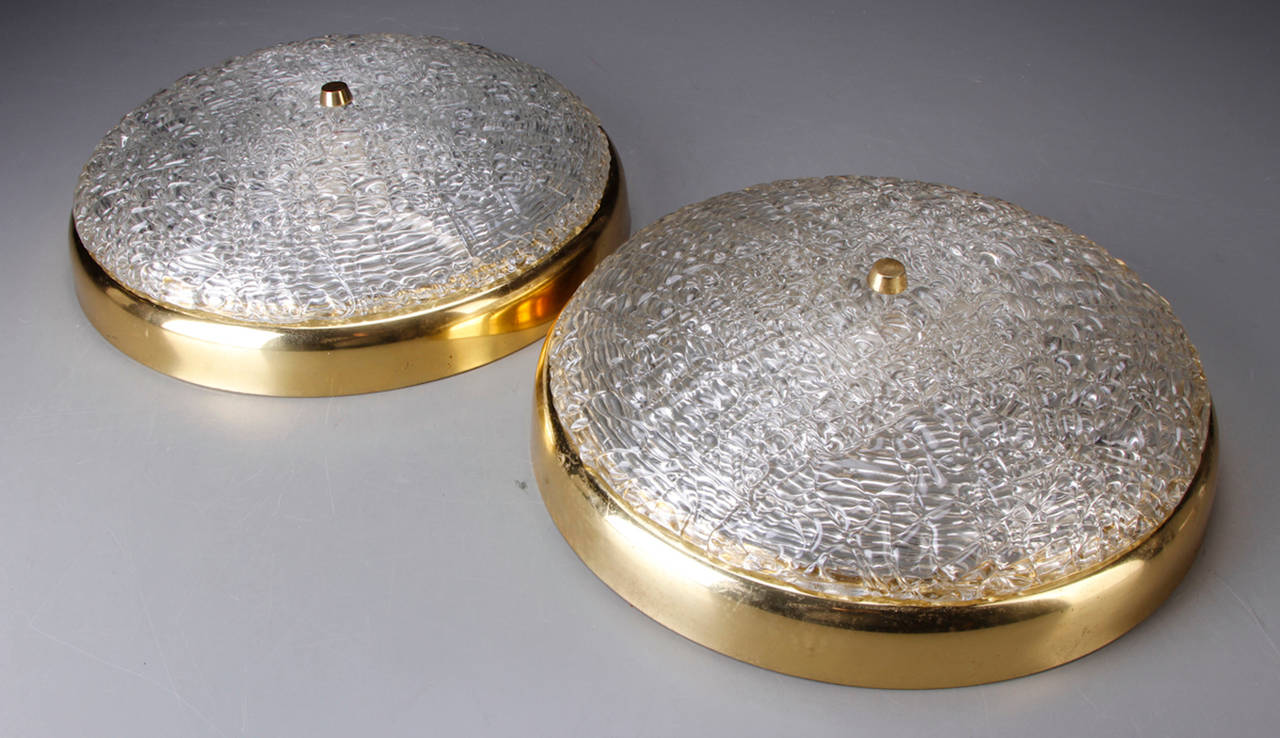 Pair of large 1950s brass-mounted molded textured glass ceiling light fixtures by designed by Carl Fagerlund for Orrefors of Sweden.