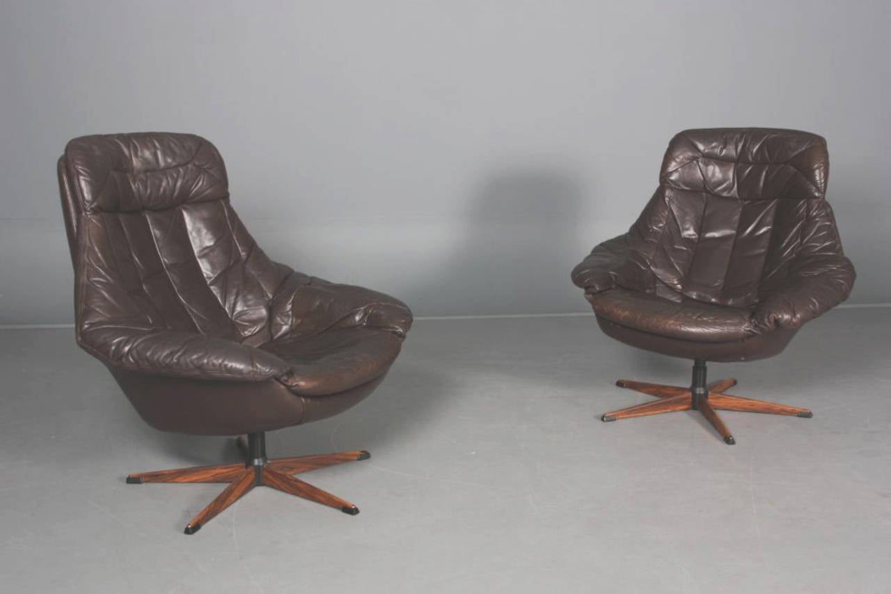 Pair of Danish H. W. Klein 1960s leather upholstered swivel chairs on steel five point star bases painted to resemble rosewood.