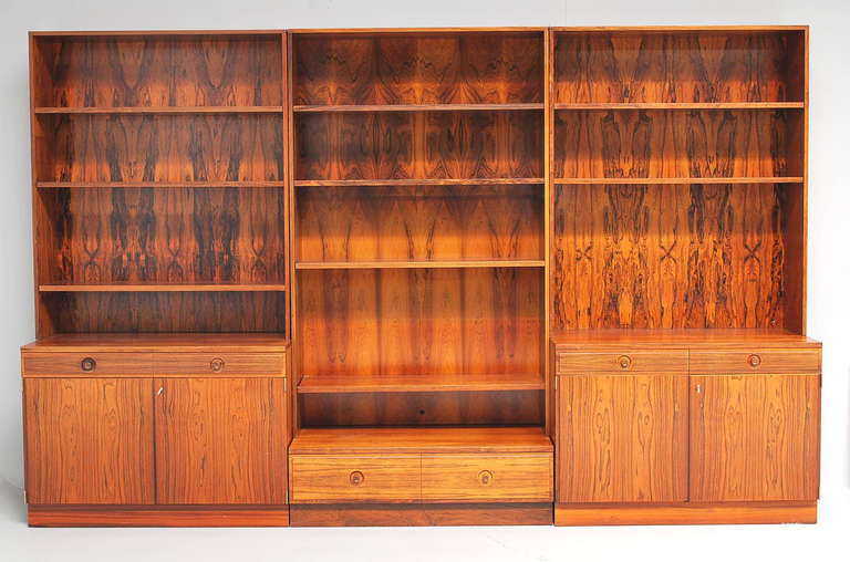 1960s-1970s well-figured rosewood three-part bookcase/shelving system. The three parts fitted with shelves over doors opening to compartments and shelving. Can work as three individual bookcases (see detail photo) each bookcase is 39 1/2