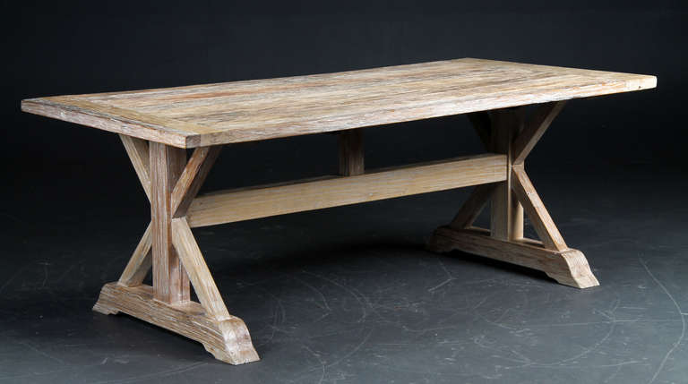 The table with plank top on two cross-ends on plinth bases.  Joined by a through stretcher.