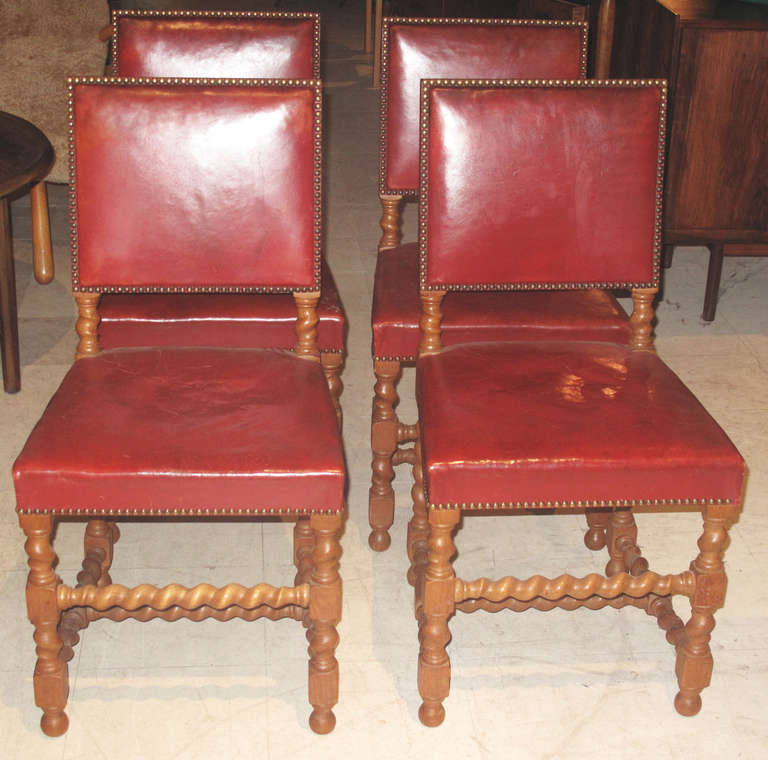 Set of Eight Late 19th-Early 20th Century Danish Jacobean Dining Chairs.  Chair frames of turned barley twist oak and raised on ball feet.  The chairs upholstered in close-nailed red leather.