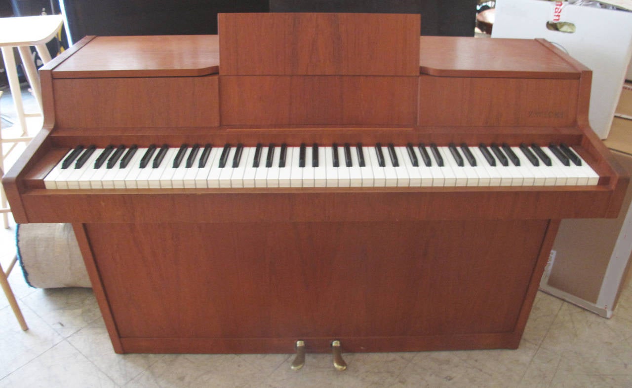 Danish modernist console piano of figured teak, circa 1960s. Made by Danish piano manufacturer Louis Zwicki. Zwicki made a limited number of these modernist pianos actually termed a pianette because it has 82 rather than the standard 88 keys, a good