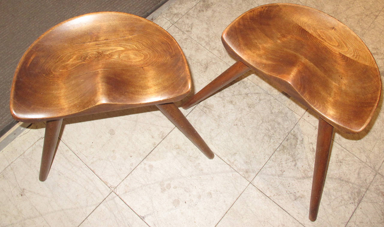 Pair of Danish beechwood milking stools with molded seats raised on three legs, 
circa 1900-1920.