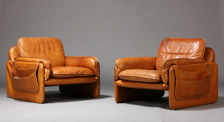 The chairs upholstered in tobacco colored leather. Chairs come with detachable side pocket bags. By De Sede of Switzerland, early 1970s.