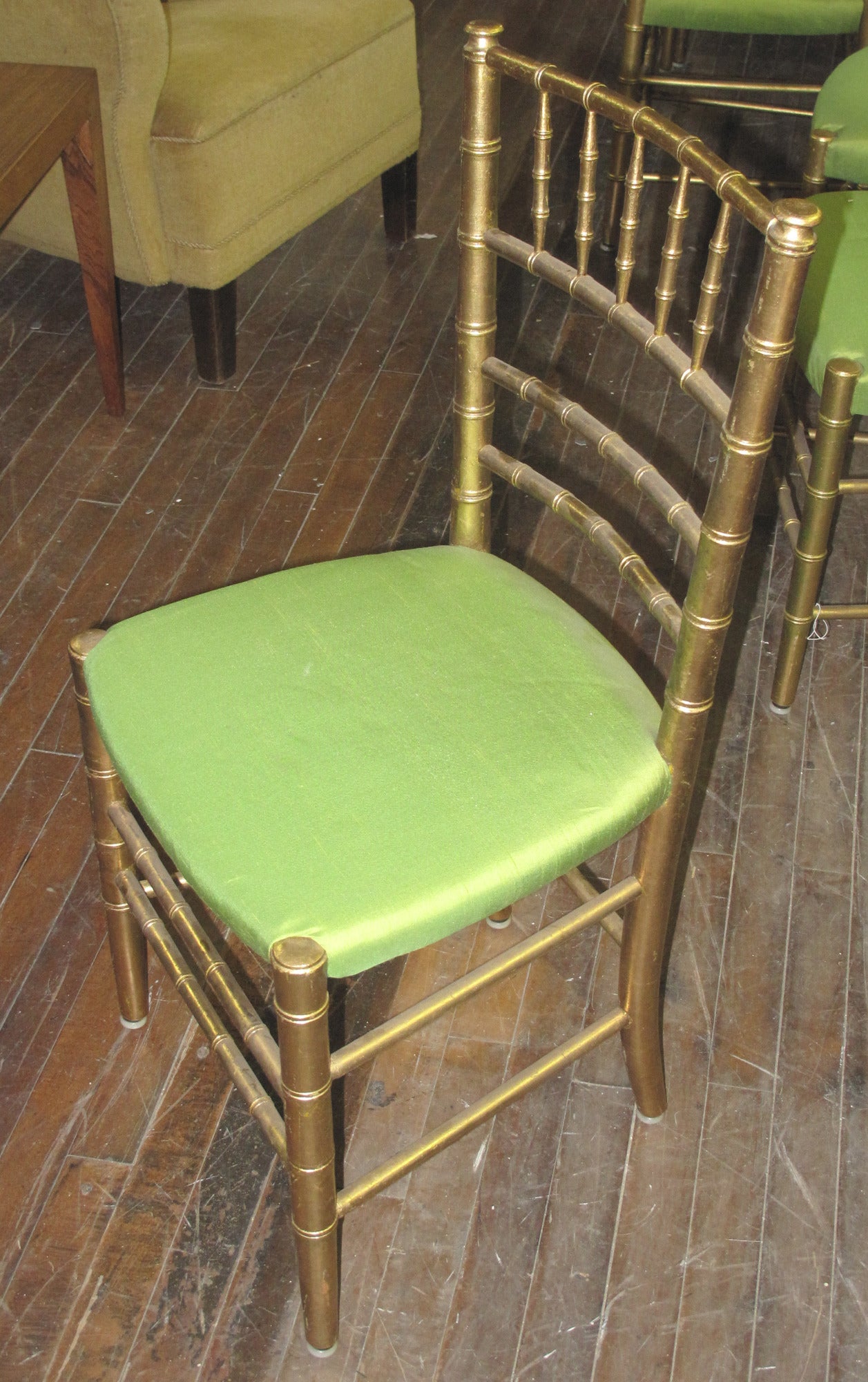 Set of 25 early 20th century giltwood ballroom chairs of bamboo form. The chairs upholstered in a chartreuse colored silk shantung.