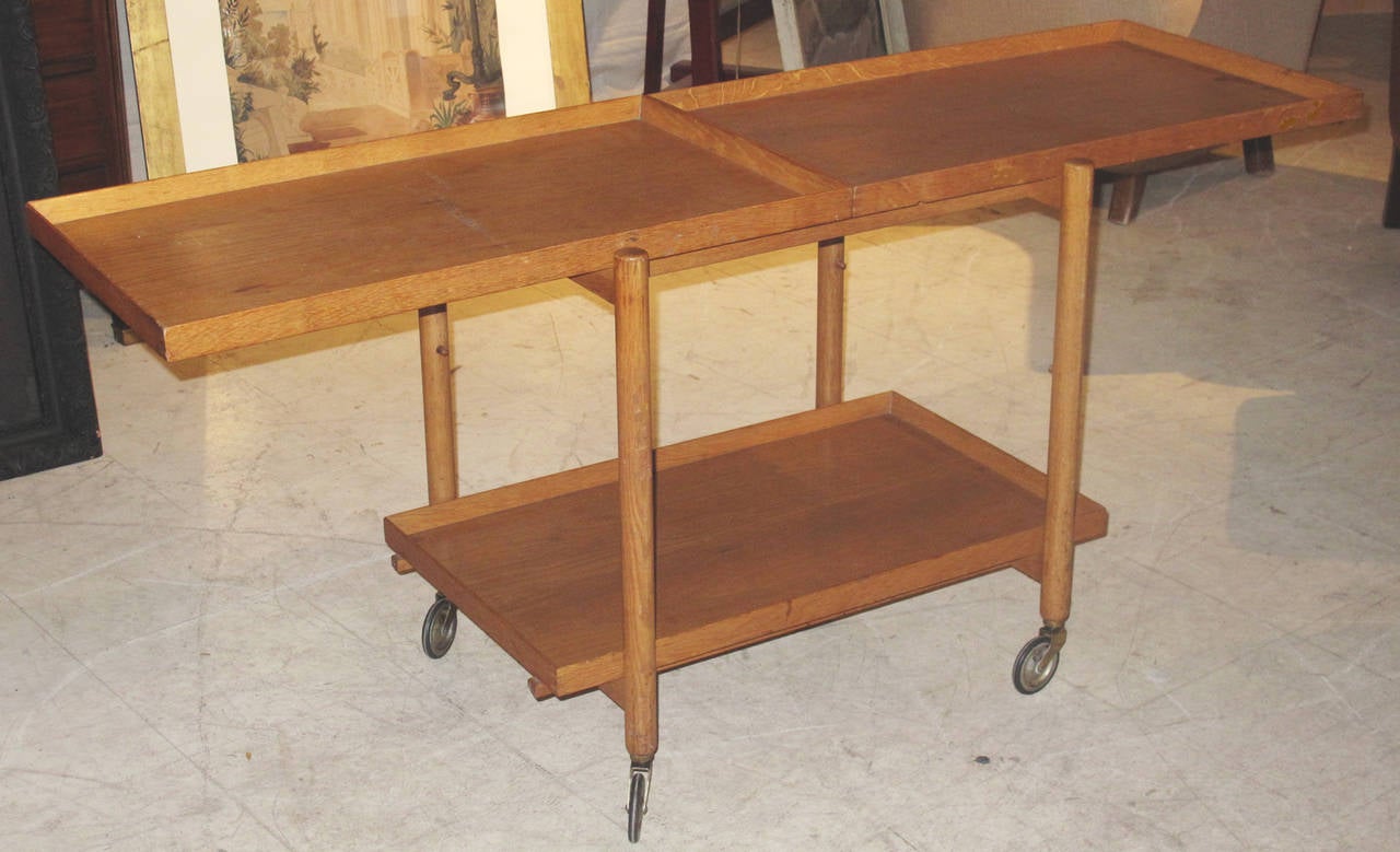 Danish 1950s-60s Oak Tray Table/Trolley on Wheels.   The middle tray can be brought out to extend the top.  With tray extended on top, total width is 59