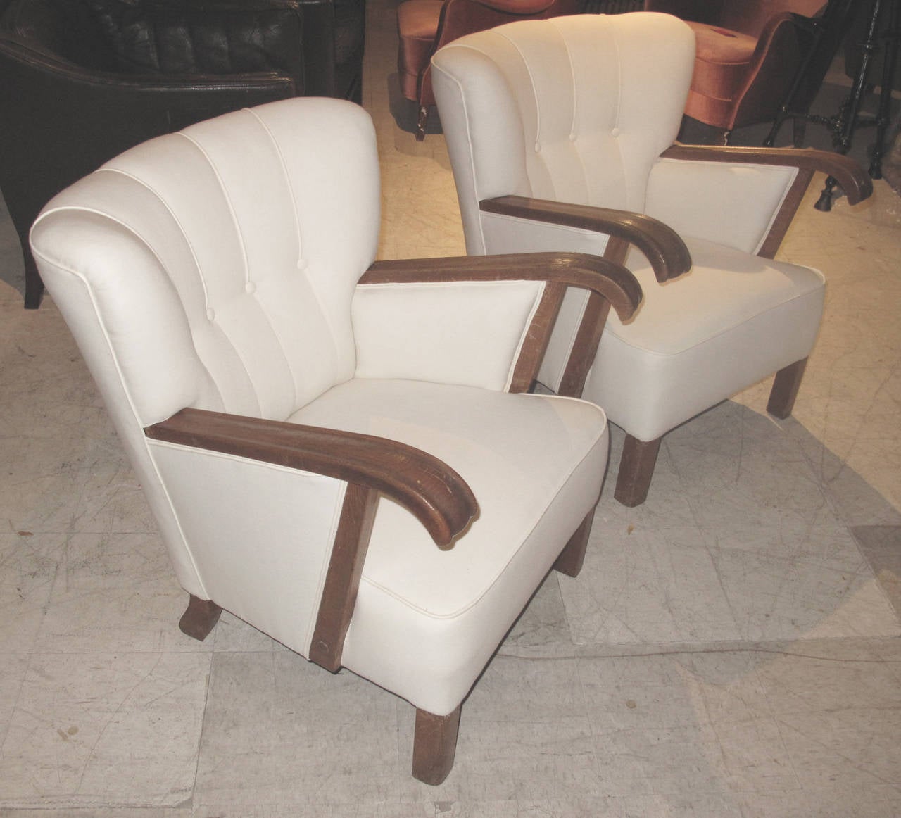 Pair of large Danish 1940s oak frame club chairs with grooved down swept arms. The chairs upholstered in muslin with channeled backs.