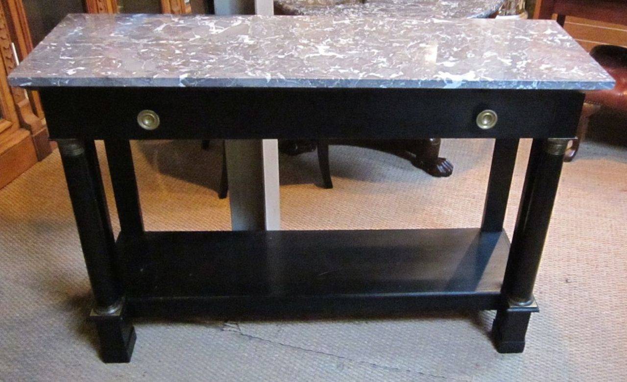 19th century French Directoire marble top, ebonized console table.
The grey with white marble top sits upon an ebonized base.  The table has brass accents, a center drawer and low shelf at the base.
It is in excellent condition.
The console table