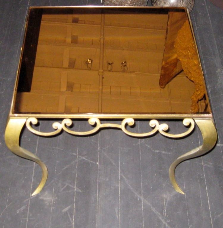 1940s French high style coffee table with a brass frame. The top is rose colored mirror.
Can be used as a coffee or side table.