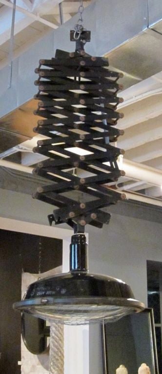 Single industrial light with and expanding arm.  The shade diameter is 22