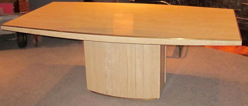 Classic Willy Rizzo travertine table. Can be used as a center hall table, desk, or dining table. Note the elliptical shape on both the top and the base. The same on both sides.
The table is trimmed in brass. This design can be found in the MOMA
