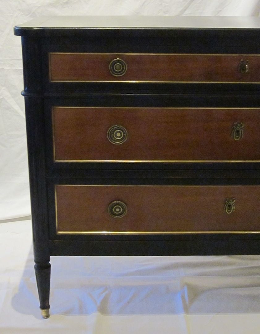 French 1940's ebony combined with pear wood bureau/commode. Painted ebony frames pear wood drawers and side panels.  Brass sabots on the legs and brass molding trims each of three drawers and side panels.  The corners of the bureau are shaped as