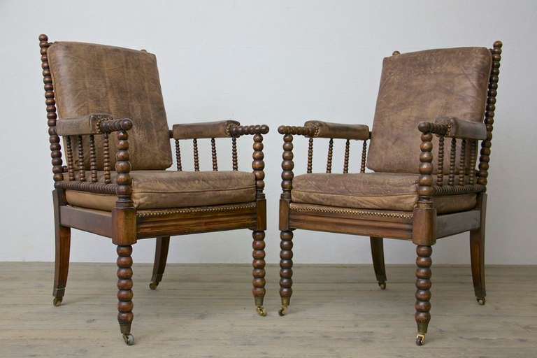 Pair of French 1950's spool leg chairs with original leather seat cushions.
Note the legs are on casters.