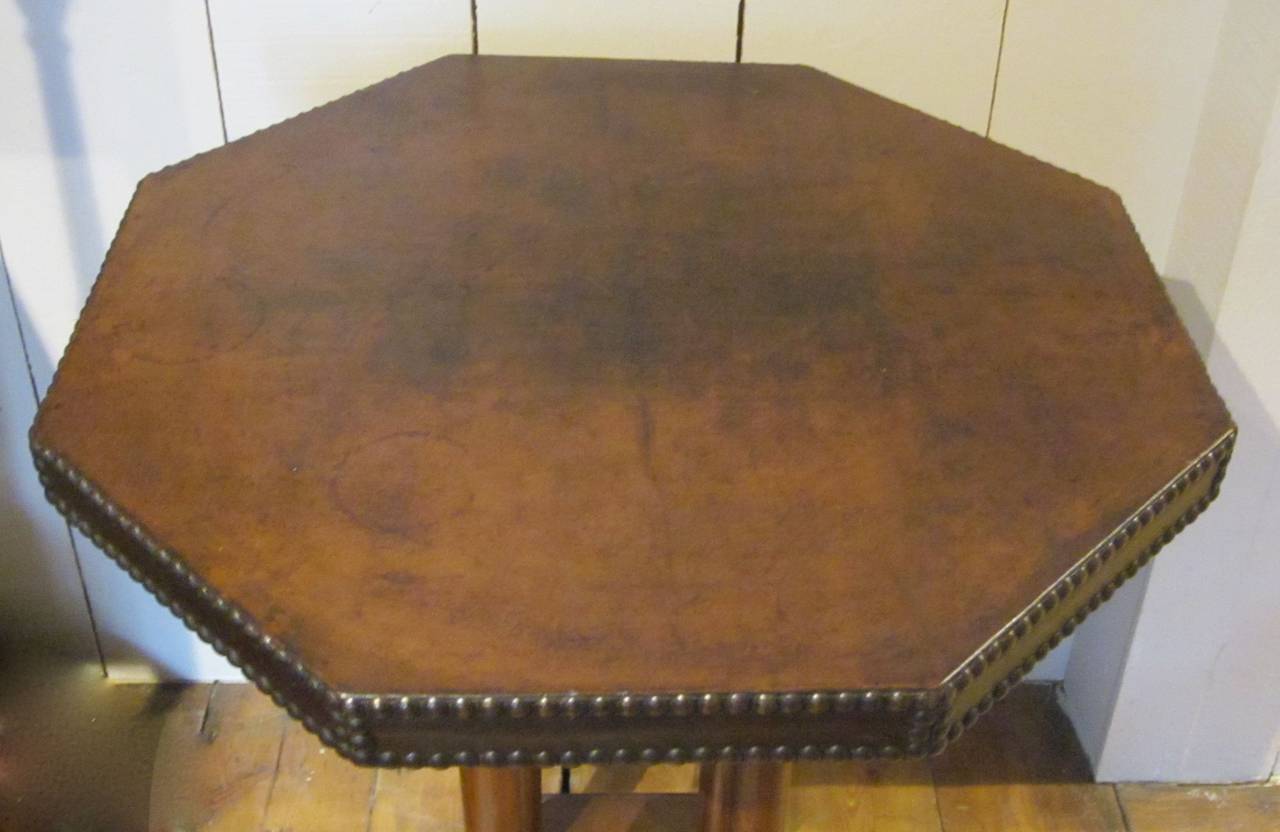 1920s English brown leather top octagonal side or end table.
The top has two rows of brass studs on the apron.
Four legs end at an octagonal base.
Excellent condition.