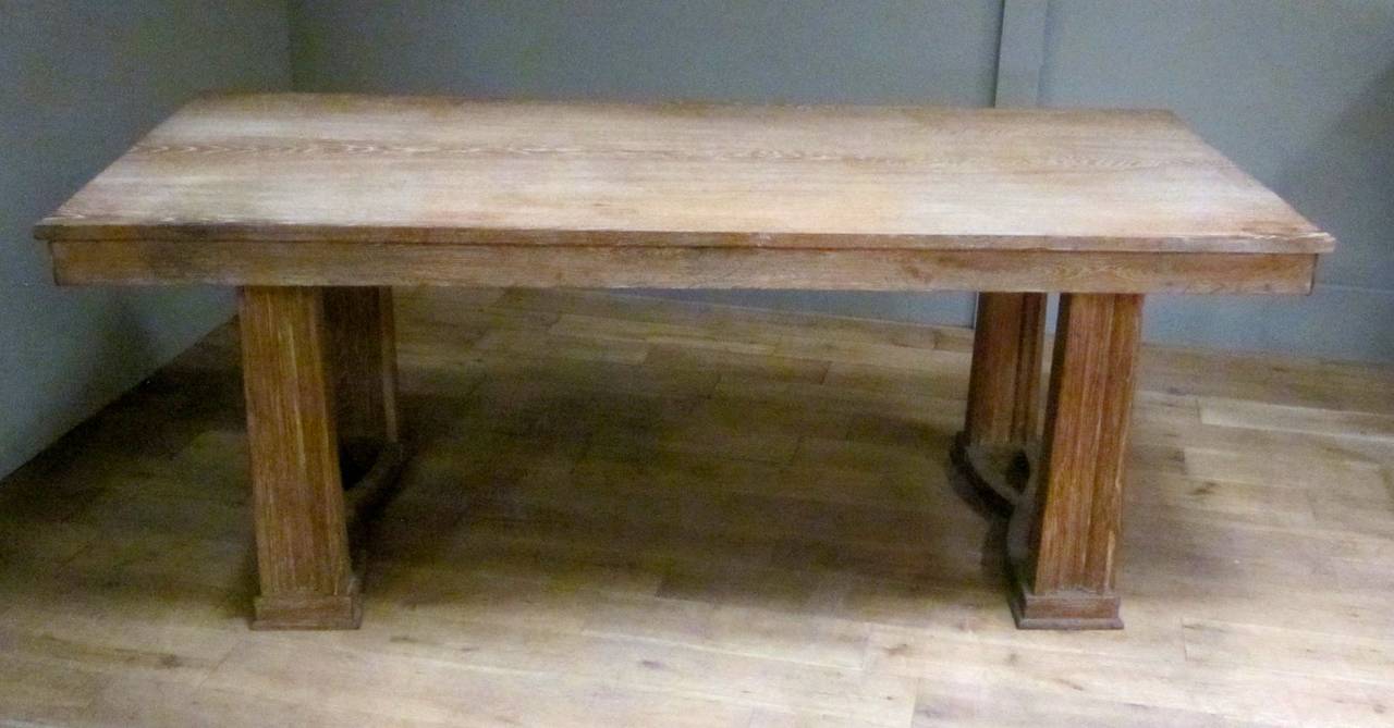 1940s French cerused oak desk with tapered column legs.  The desk has very clean, smooth lines while the cerusing enhances the wood grain.
A criss cross detail connects the front and back legs at the base.
The desk is in excellent