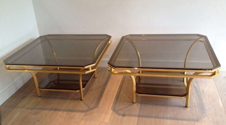 Two-tiered brass frame and smoked glass square coffee tables.
Each tier holds a smoked glass shelf. The table has very clean brass lines.
A pair is available and in excellent condition. Sold individually.