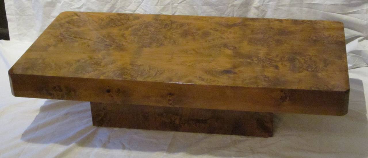 1970s French burl wood lacquered rectangular coffee table.
The high polish enhances the beautiful brown and light rust tones of the wood grain.
The top is four inches thick with straight, flat corners. It sits atop a base measuring 27