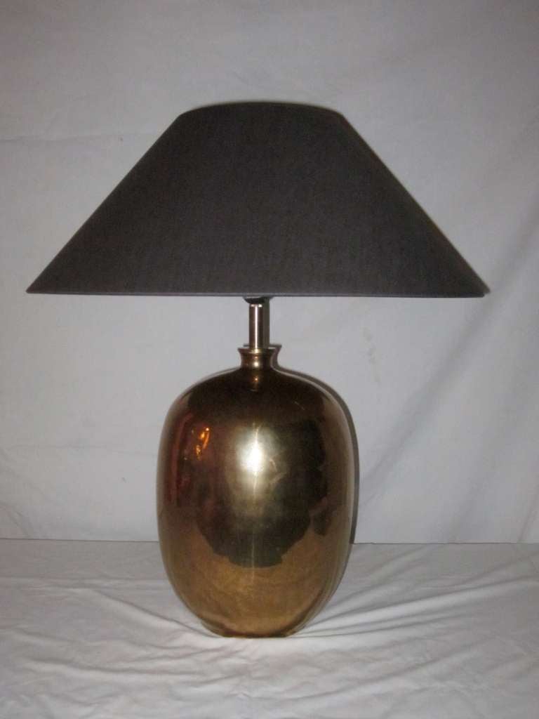 Contemporary pair of gold faux shagreen egg shaped lamps. The faux shagreen pattern is transferred onto a porcelain base. The shades are espresso color fine Belgian linen with metallic gold interiors.
The dimensions are 10