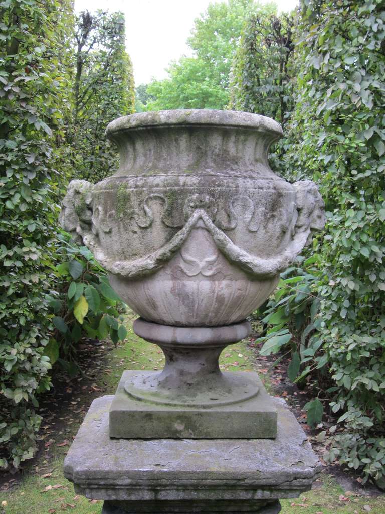 Early 19th century carved limestone garden urn, with 2 lion heads and garlands in bas relief
29