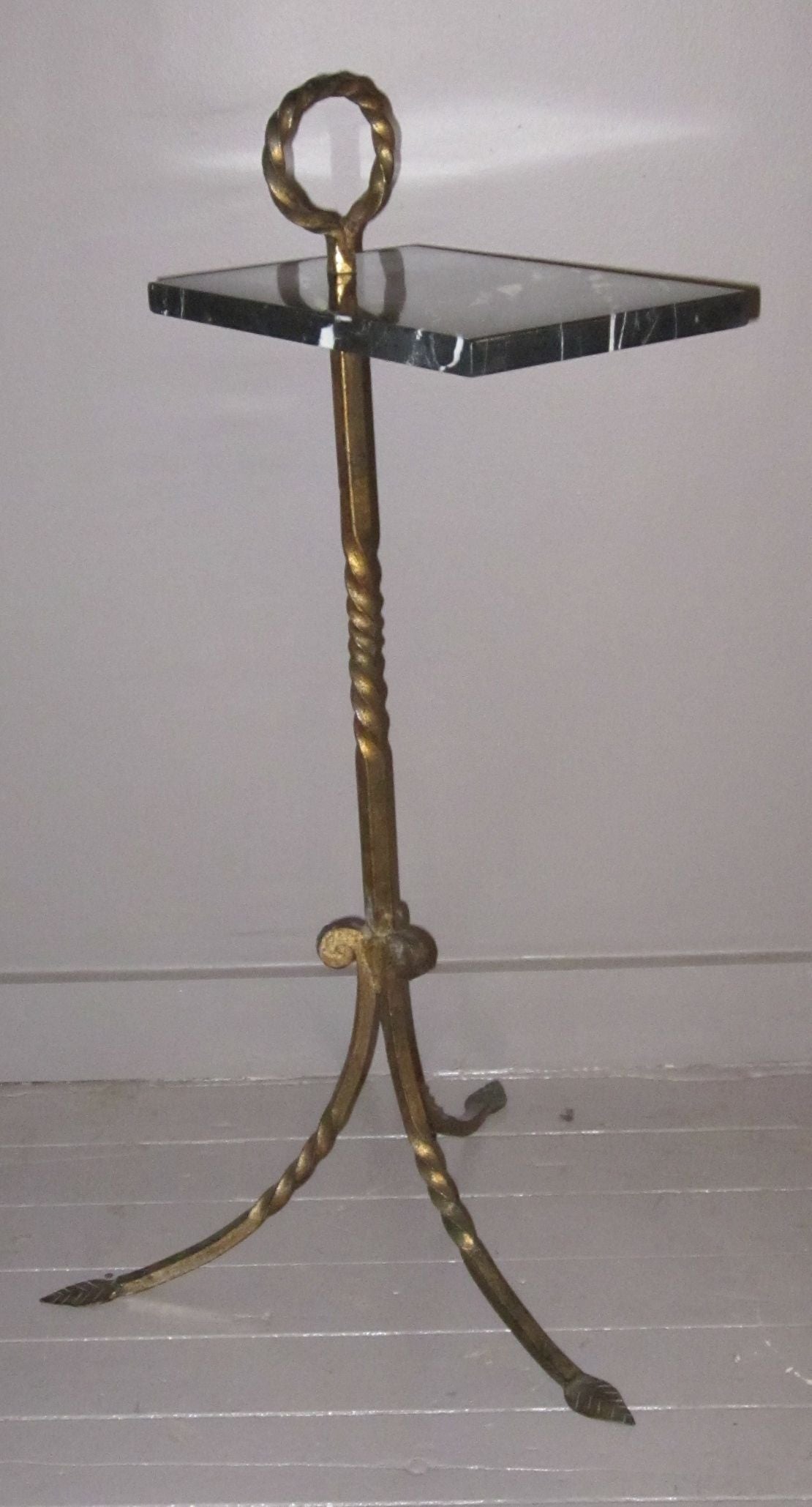 1960s Spanish gold gilt metal base has tripod leaf motif feet and twisted ring reaching above the rectangular black and white marble top.
Measures: Height to marble top is 27