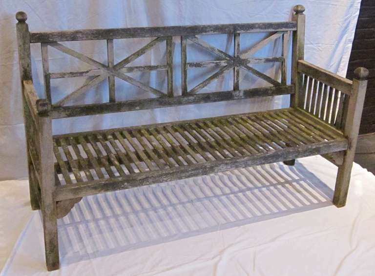 Teak garden bench designed by English landscape designer Gertrude Jekyll.
Slatted seat and side arms with Union Jack pattern on back