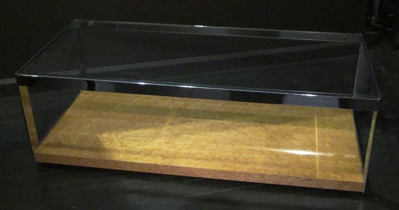 1970s two-tier rectangular coffee table, attributed to Merrow of Guildford, England. The beauty of the bird's-eye maple base can be seen through the glass top. Chrome frames the entire table. It is in excellent condition.